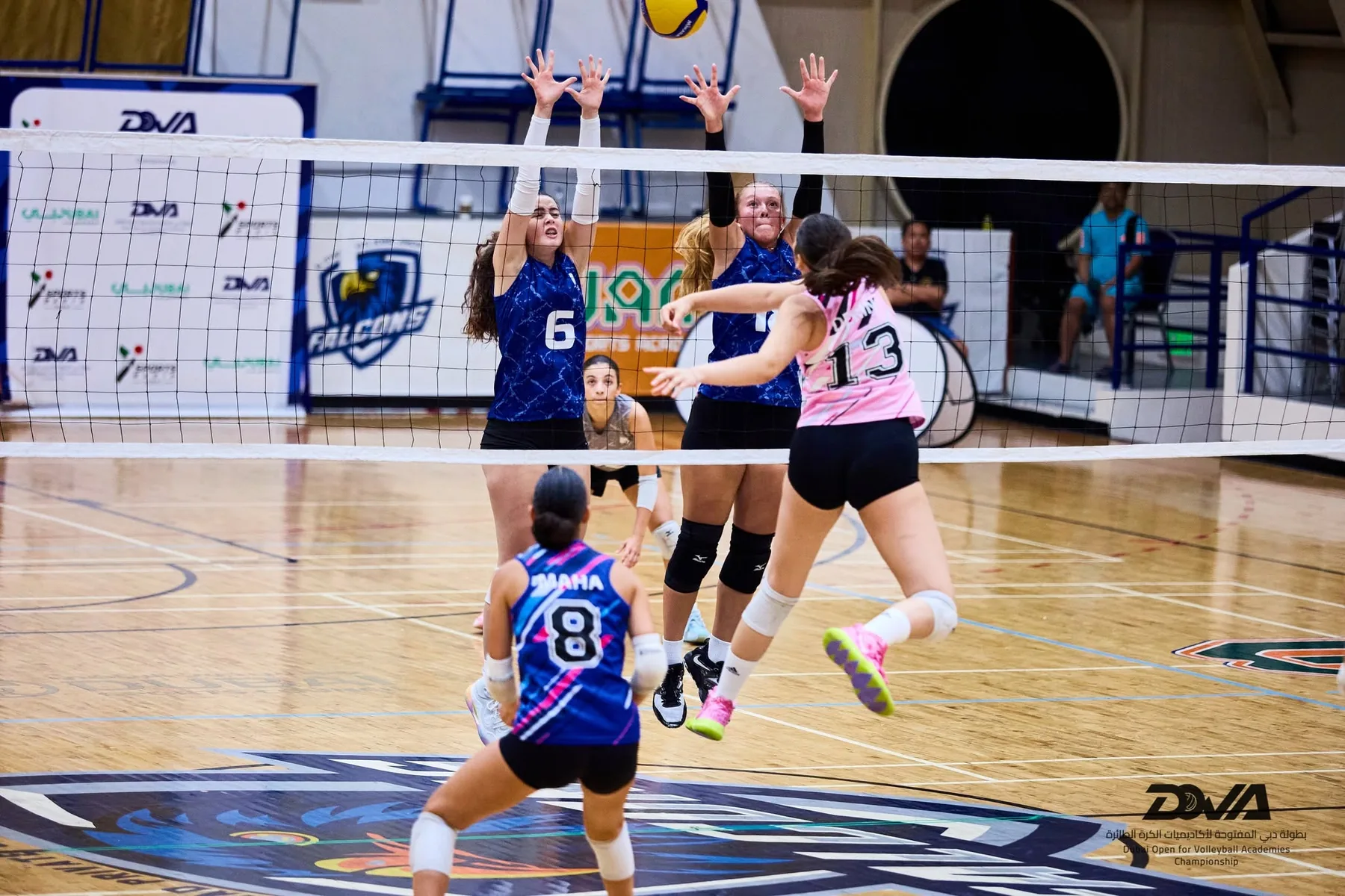Two DOVA players blocking a spike at the net